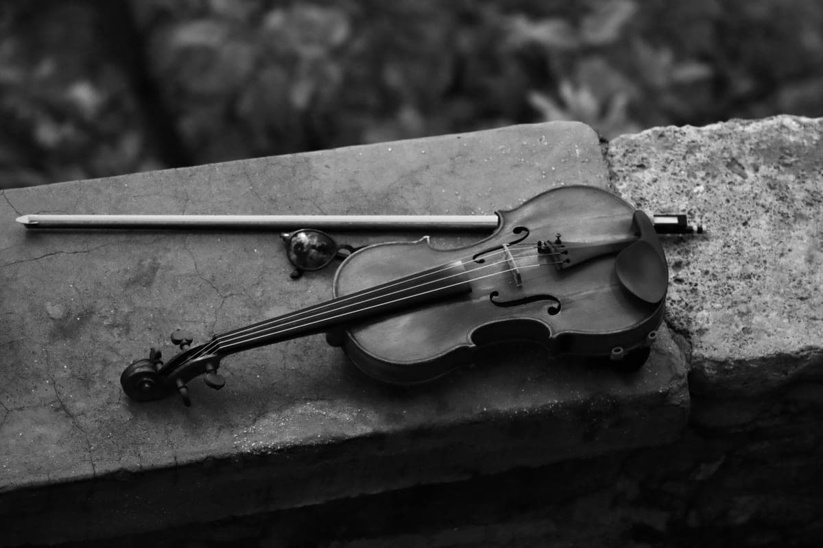 A violin and bow resting on a pale surface